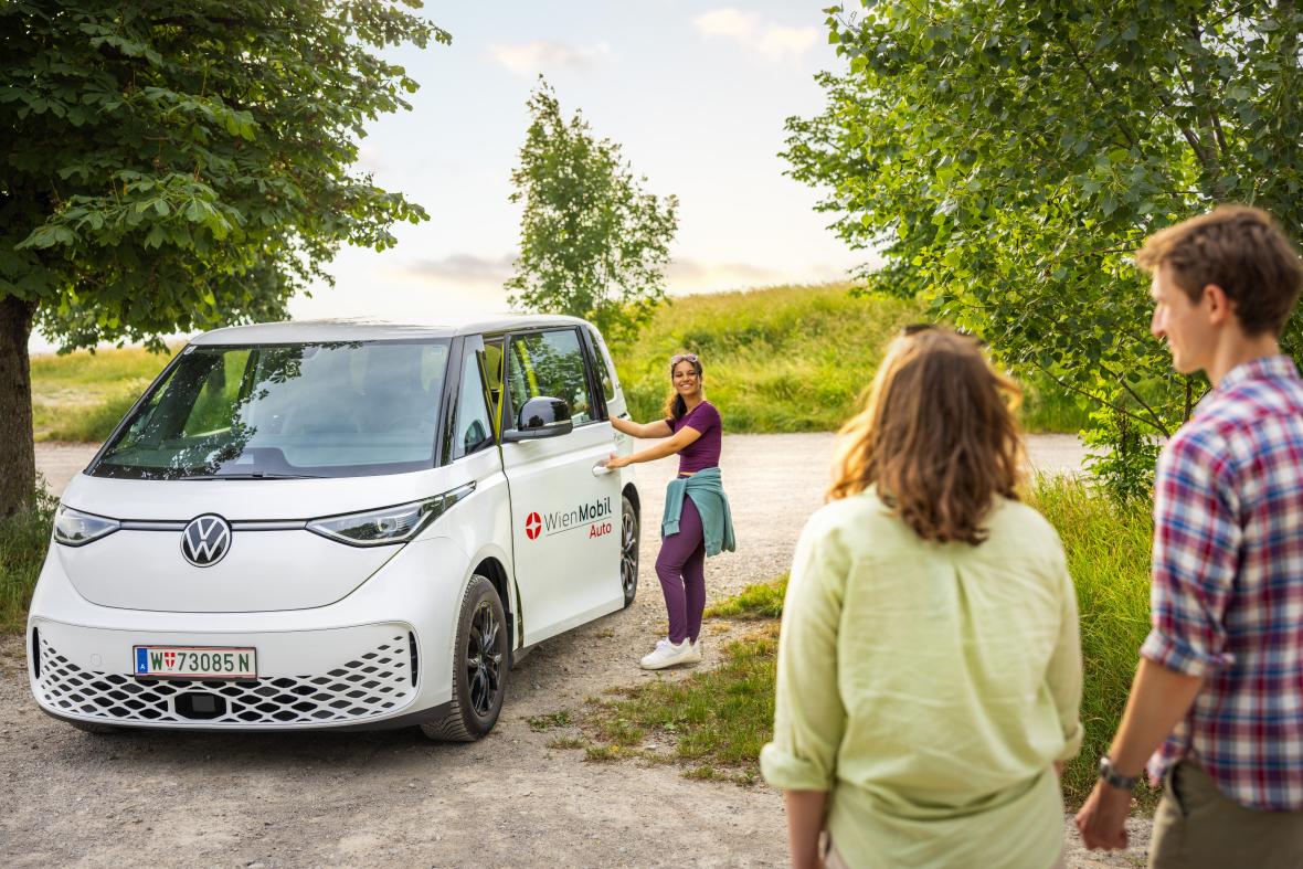 Junge Leute machen einen Ausflug mit elektrischem VW-Bus der Wiener Linien