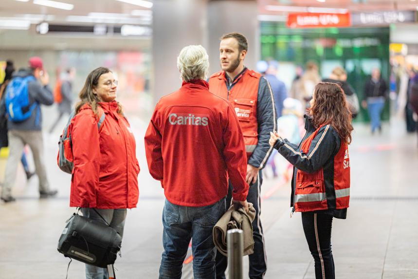 mehrere Personen stehen in einer Ubahnstation und sprechen miteinander