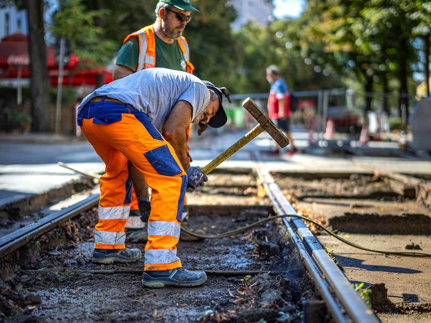 Ein Bauarbeiter arbeitet mit einem Pickel auf der Gleisbaustelle Wiedner Hauptstraße