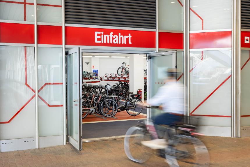 Mitarbeiter fährt mit Fahrrad in die Fahrradgarage in der Firma