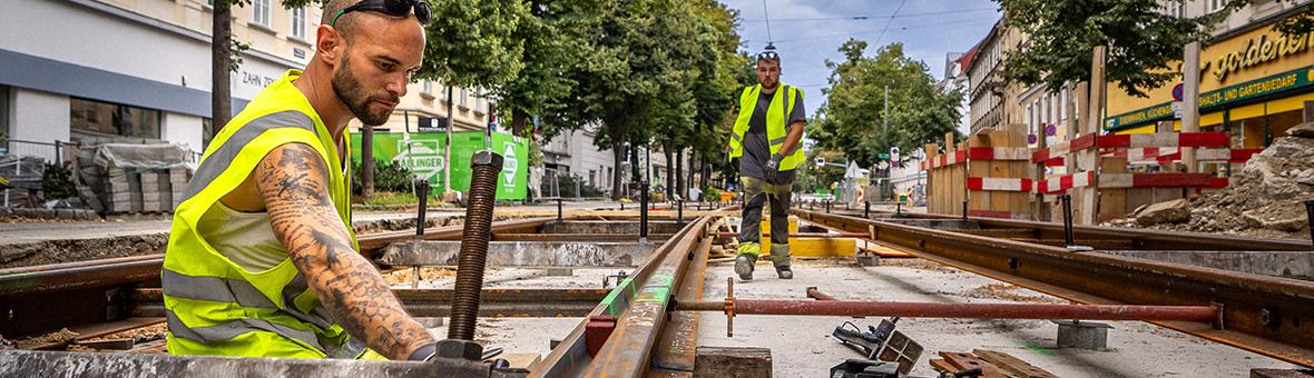 Men in work clothes lay new rails