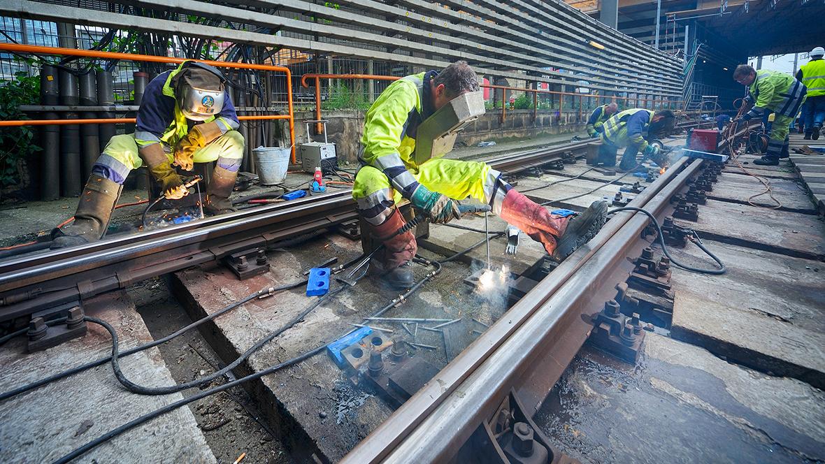 Gleisbauarbeiter schweißt Schienen der U4