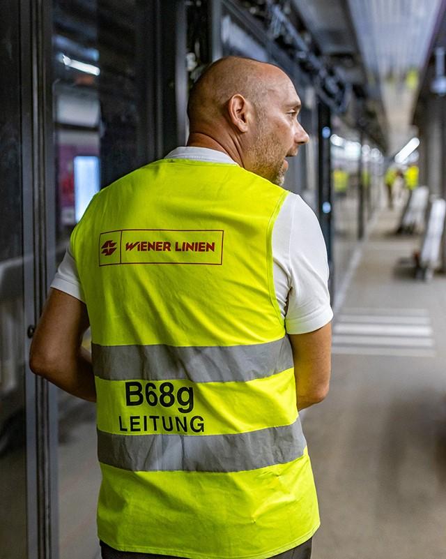 ein Mann mit gelber Warnweste und der Aufschrift Wiener Linien B68g Leitung in einer Station der U2 Stammstrecke