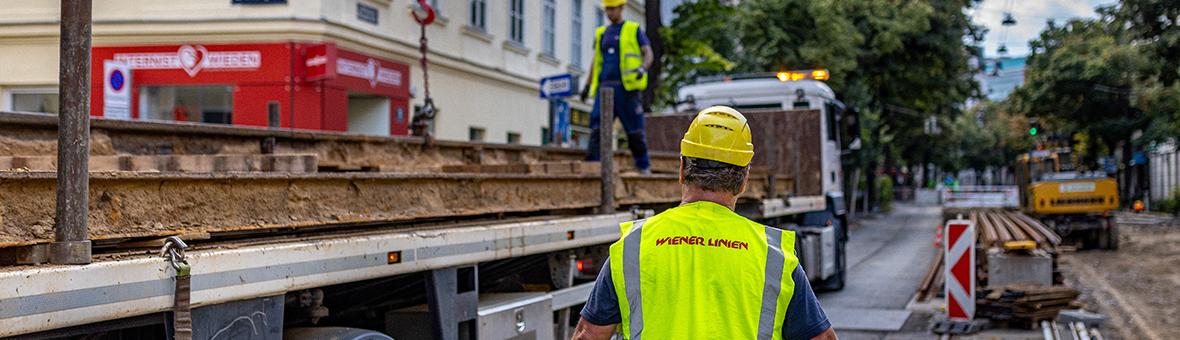 Construction site workers delivering and installing new tram tracks